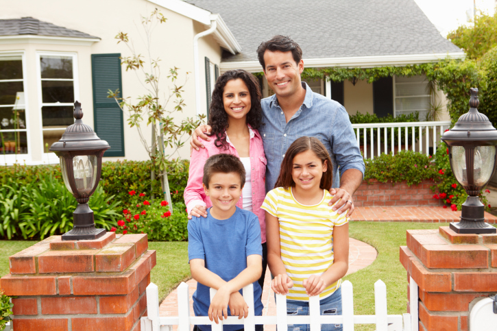 family standing with home